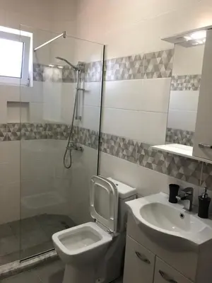 a bathroom with a toilet and a sink and a shower at Margaritaville in Ulcinj