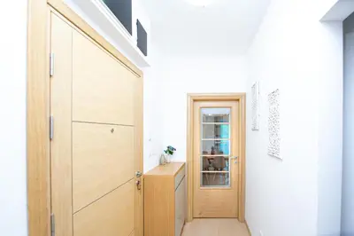 a hallway with a wooden door and a table at Apartman DULY LUX in Pržno