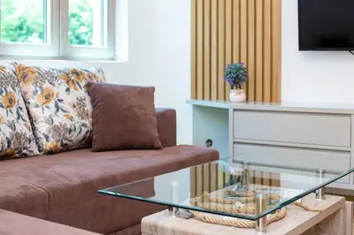 a living room with a couch and a glass coffee table at Apartman DULY LUX in Pržno