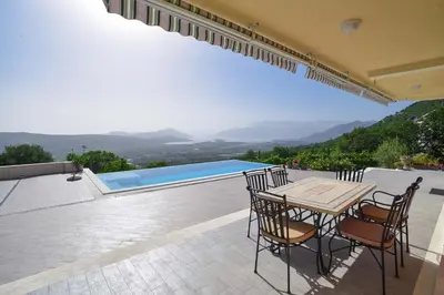 a patio with a table and chairs and a pool at Verbalj apartment with swimming pool in Kotor