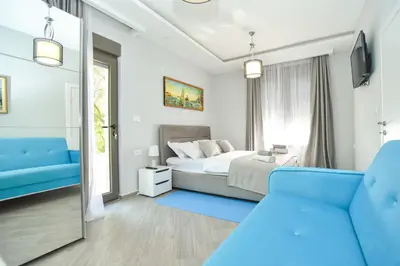 a bedroom with a bed and a blue couch at Verbalj apartment with swimming pool in Kotor