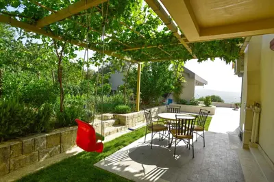 a patio with a table and chairs under a pergola at Verbalj apartment with swimming pool in Kotor