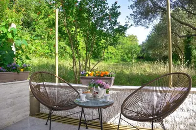 two chairs and a table with flowers on a patio at Verbalj apartment with swimming pool in Kotor