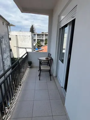 a balcony with a table and a chair on it at Nikolić Apartmani in Bar