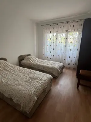 a bedroom with two beds and a window with curtains at Nikolić Apartmani in Bar