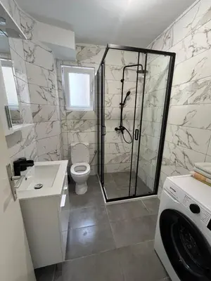 a bathroom with a shower and a toilet at Nikolić Apartmani in Bar