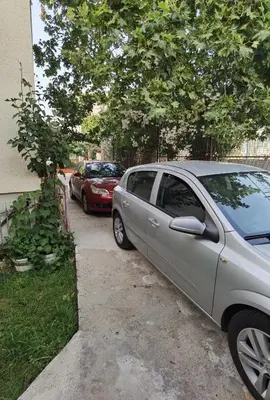 a silver car parked in a driveway next to a house at Nikolić Apartmani in Bar