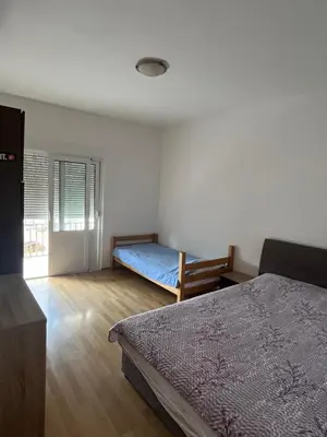 a bedroom with a bed and a bed sidx sidx sidx sidx at Nikolić Apartmani in Bar