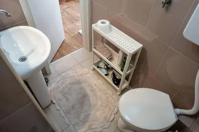 a bathroom with a white toilet and a sink at M&B apartment in Kotor