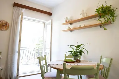 a dining room with a table and chairs and a window at M&B apartment in Kotor