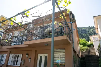 a balcony of a house with a staircase in front at M&B apartment in Kotor