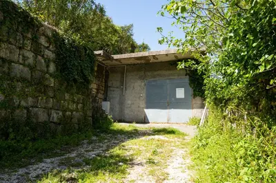 a garage with a door in a brick wall at M&B apartment in Kotor