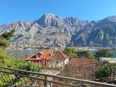 a view of a house with mountains in the background at M&B apartment in Kotor