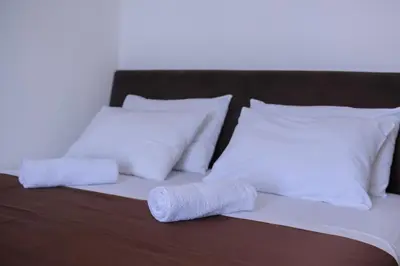 a bed with two white pillows and a blanket at MS Hotel in Dobra Voda