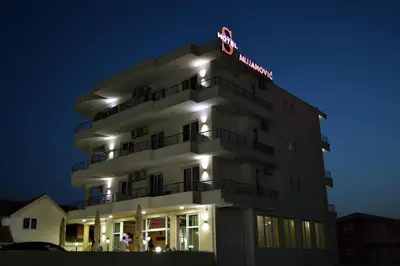 a white building with a sign on top of it at MS Hotel in Dobra Voda