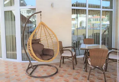 a hanging hammock chair in a room with a table at MS Hotel in Dobra Voda