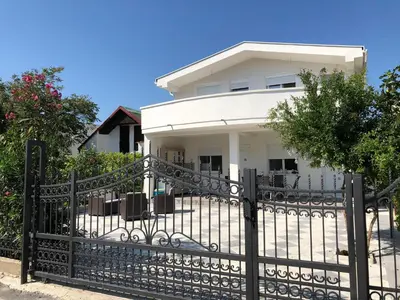 a black fence in front of a white house at Villa Dafina in Donji Štoj