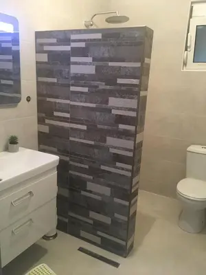a bathroom with a wooden wall next to a toilet at Villa Dafina in Donji Štoj
