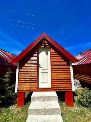 a small house with a red roof and a door at Vikendica,Bungalovi Lipska pećina in Cetinje