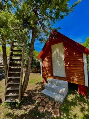 a small cabin with a staircase next to a tree at Vikendica,Bungalovi Lipska pećina in Cetinje
