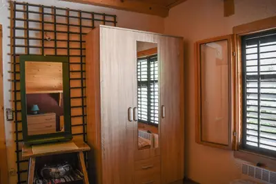 a room with a mirror and a cabinet and windows at Guest House Scepanovic in Sutomore