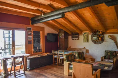 a living room with wooden ceilings and a table and chairs at Guest House Scepanovic in Sutomore