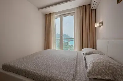 a bedroom with a bed with a large window at BigMontenegro Dreams in Becici