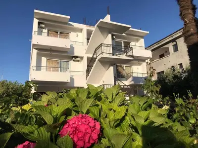 a building with a bunch of flowers in front of it at B&B Lovac Hasa in Ulcinj