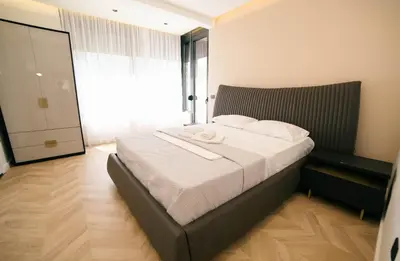 a bedroom with a bed with white sheets and a window at B&B Lovac Hasa in Ulcinj