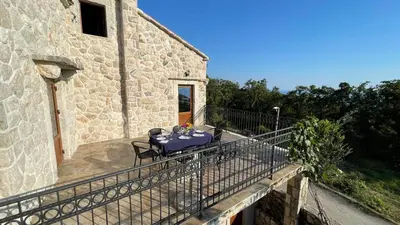 a table on a balcony of a stone building at Mountains Villa near Budva in Budva