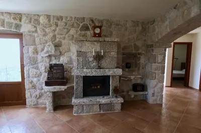 a stone fireplace in a room with a stone wall at Mountains Villa near Budva in Budva