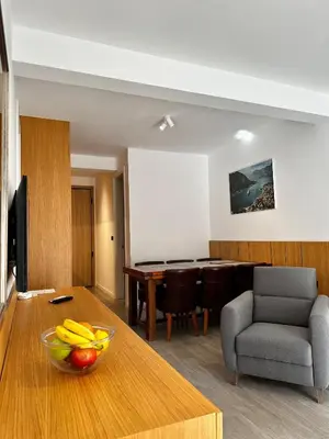 a living room with a table with a bowl of fruit on a table at Dubrave apartmani in Budva