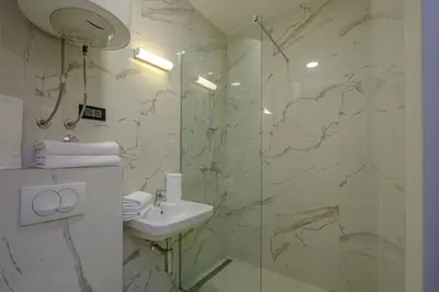 a bathroom with a sink and a glass shower at Dubrave apartmani in Budva