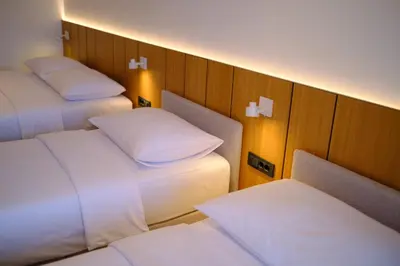 a room with three beds with white pillows at Dubrave apartmani in Budva