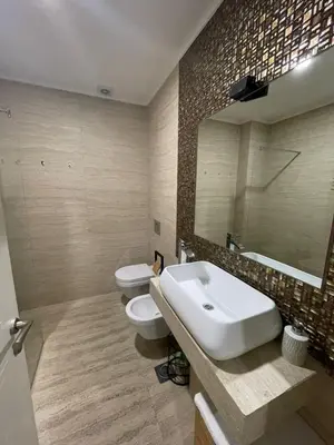 a bathroom with two toilets and a sink and a mirror at Luxury apartment in Victoria Palace Budva center in Budva