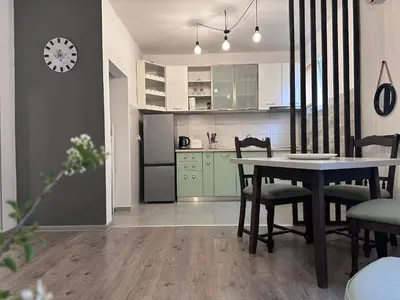 a kitchen and dining room with a table and chairs at W Apartments in Kotor