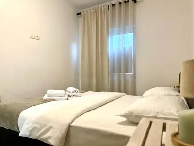 a bedroom with a large white bed with towels on it at W Apartments in Kotor