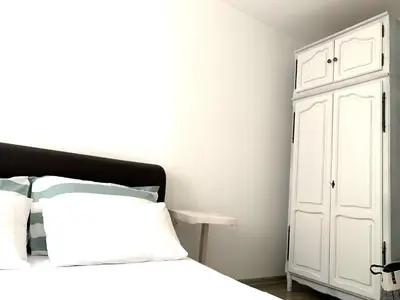 a bedroom with a bed and a white cabinet at W Apartments in Kotor