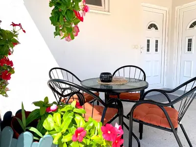 a patio with a table and chairs and flowers at W Apartments in Kotor