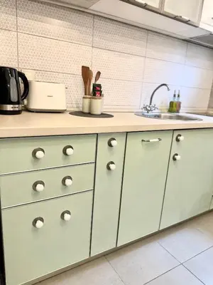 a kitchen with white cabinets and a sink at W Apartments in Kotor