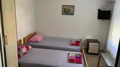 a small room with two beds and a television at Vila Marina in Sutomore