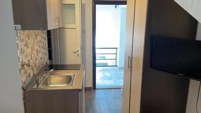 a kitchen with a sink and a door to a hallway at Vila Marina in Sutomore