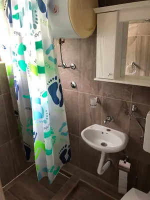 a bathroom with a sink and a shower curtain at Vila Marina in Sutomore