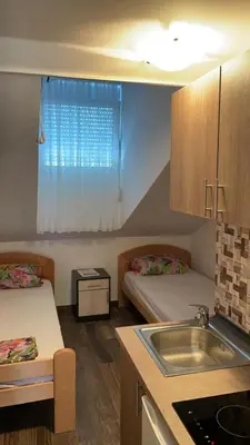 a small room with two beds and a sink at Vila Marina in Sutomore