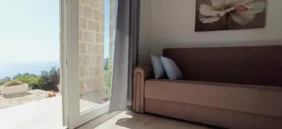 a living room with a couch and a window at Almond Apartments in Sveti Stefan