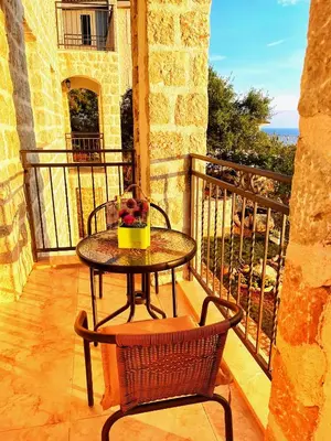 a table and chairs on a balcony with a view of the ocean at Almond Apartments in Sveti Stefan
