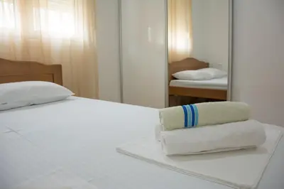 a bed with two towels sitting on it in front of a mirror at Apartments Milica in Becici
