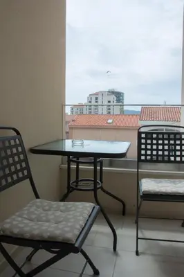 a table and two chairs on a balcony with a window at Apartments Milica in Becici