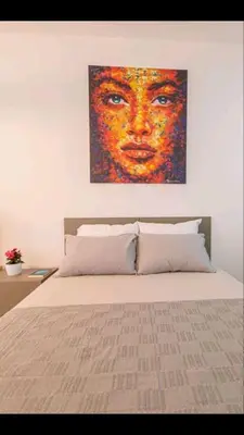 a bedroom with a bed with a painting on the wall at DiVa Lux Apartment in Soho City complex in Bar