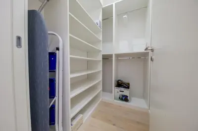 a walk in closet with white shelves at DiVa Lux Apartment in Soho City complex in Bar
